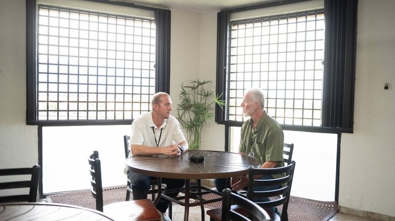 Two people talking in a bright meeting room at the Florida Helps center